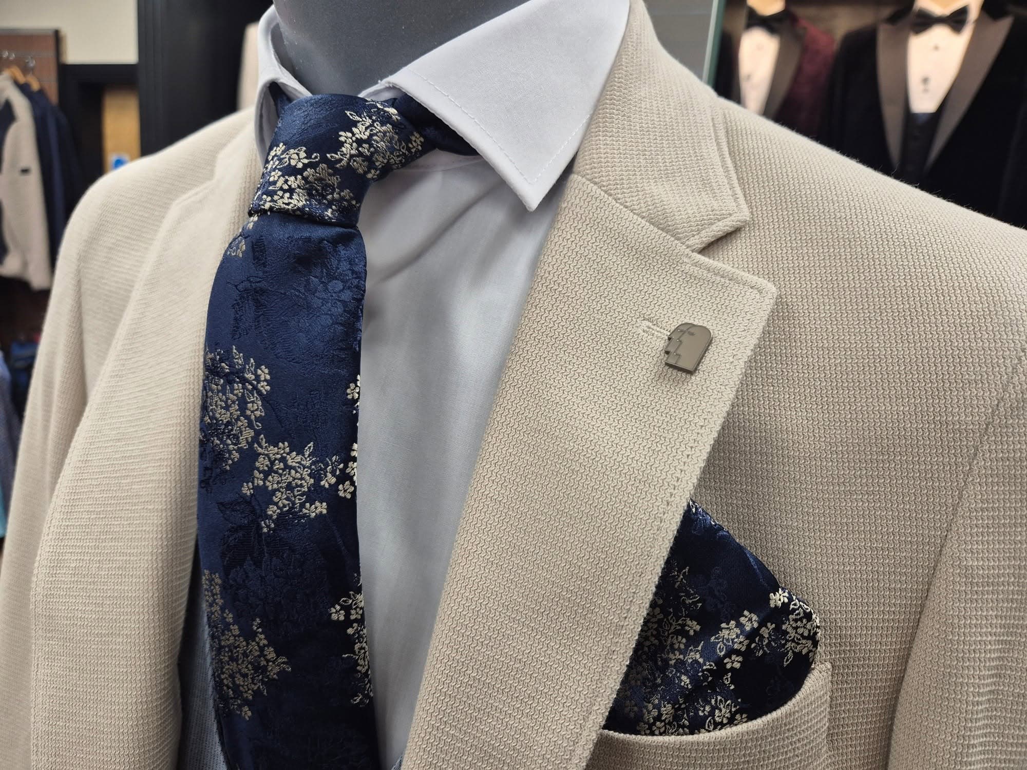 Beige textured wedding jacket with a navy floral tie and pocket square